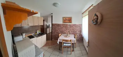 a small kitchen with a table and a brick wall at Apartma Studio Bogi in Kranjska Gora