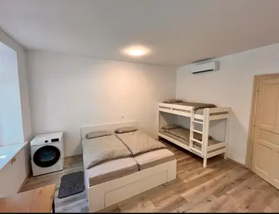 a bedroom with a bed and a bunk bed and a room with a door at Apartment Bon Voyage II in Maribor
