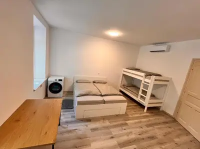 a room with two bunk beds and a table at Apartment Bon Voyage II in Maribor