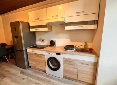 a kitchen with a washing machine and a sink at Apartment Bon Voyage II in Maribor
