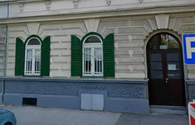 a building with green and white windows and a door at Apartment Bon Voyage II in Maribor