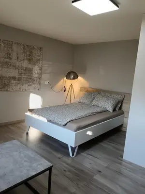 a bedroom with a bed with a lamp and a table at Apartma dolgi most in Ljubljana