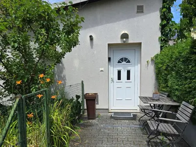 a white door of a white house with a bench at Apartma dolgi most in Ljubljana