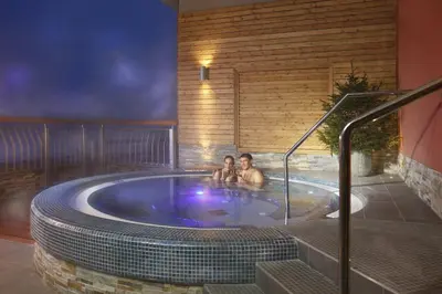 two people are sitting in a hot tub at Hotel Natura in Zreče
