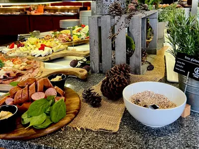 a table topped with plates of food on a counter at Hotel Natura in Zreče