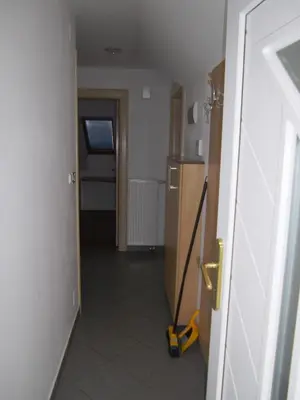 a hallway with a mop in a room with a kitchen at Apartmaji Kranjska Gora in Kranjska Gora