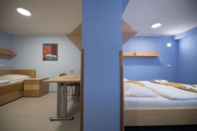 a bedroom with a bed and a desk and a table at S Hotel in Maribor