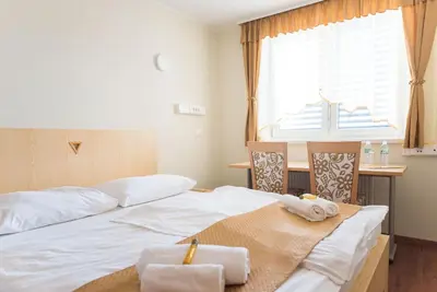 a room with two beds and a desk and a window at S Hotel in Maribor