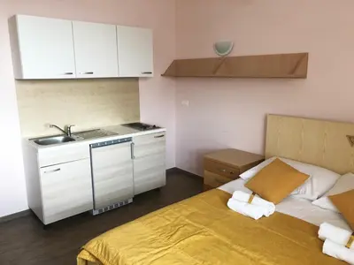 a small kitchen with a bed and a sink at S Hotel in Maribor
