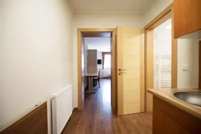 a kitchen with a sink and a door to a room at S Hotel in Maribor