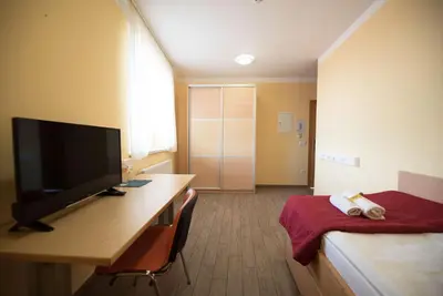 a room with a desk with a television and a bed at S Hotel in Maribor