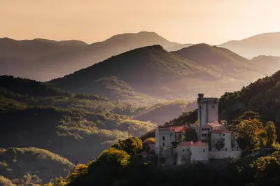 a castle on a hill with mountains in the background at PREMIUM B&B Nova Gorica, Self Check-In with code access in Nova Gorica