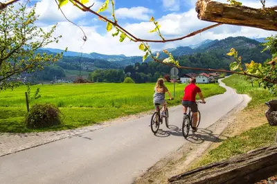a man and a woman riding bikes down a road at Farm Stay Pirc - Hayloft Apartment in Laško