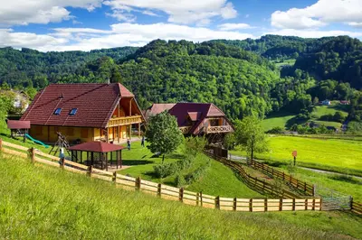 a house in the middle of a field with a fence at Farm Stay Pirc - Hayloft Apartment in Laško
