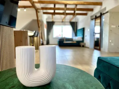 two white vases sitting on a table in a living room at City Central Loft with Parking in Maribor