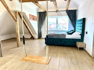 a swing in a room with a bed and a window at City Central Loft with Parking in Maribor