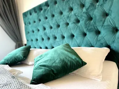 a bed with green pillows and a green headboard at City Central Loft with Parking in Maribor