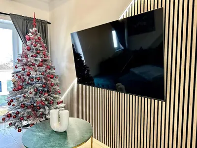 a christmas tree in a living room with a table at City Central Loft with Parking in Maribor