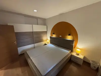 a bedroom with a large bed with an arch above it at Apartma Vila De Casa in Ribnica