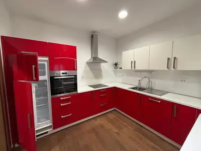 a red kitchen with white cabinets and a sink at Apartma Vila De Casa in Ribnica