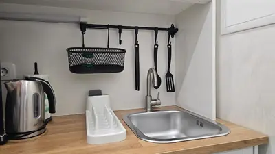 a kitchen counter with a sink and utensils at Teeny tiny in Šentvid