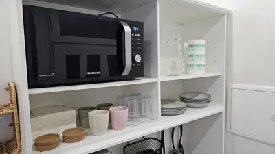 a microwave oven sitting on top of a shelf at Teeny tiny in Šentvid