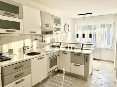 a white kitchen with a sink and a counter top at Colorful Central Apartment in Maribor in Maribor
