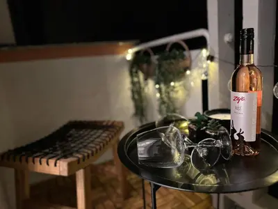 a bottle of wine sitting on a table with glasses at Colorful Central Apartment in Maribor in Maribor