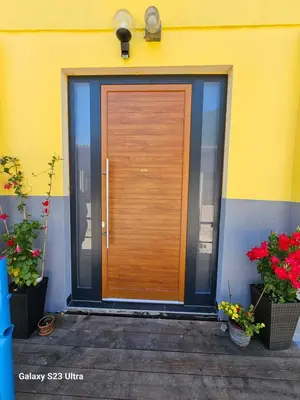 a wooden door on the side of a building with flowers at Avecchiasegheria in Most na Soči
