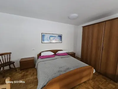 a bedroom with a bed and a wooden cabinet at Avecchiasegheria in Most na Soči