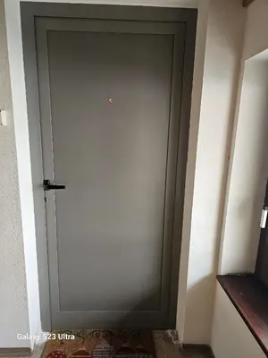 a gray door in a room with a wall at Avecchiasegheria in Most na Soči