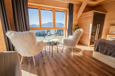 a bedroom with two chairs and a table and a bed at Studio Wild Park Panorama with Hot tub and Sauna in Tolsti Vrh pri Ravnah naKoroškem