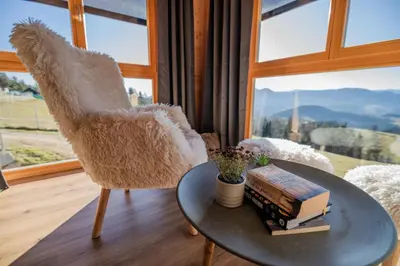 a room with a table and a chair with books at Studio Wild Park Panorama with Hot tub and Sauna in Tolsti Vrh pri Ravnah naKoroškem