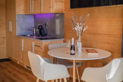 a kitchen with a table and chairs and a sink at Studio Wild Park Panorama with Hot tub and Sauna in Tolsti Vrh pri Ravnah naKoroškem