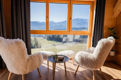 a room with two chairs and a table and a large window at Studio Wild Park Panorama with Hot tub and Sauna in Tolsti Vrh pri Ravnah naKoroškem
