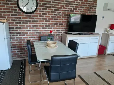 a dining room with a table and chairs and a clock at Apartments Isabella in Ptuj
