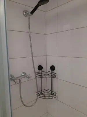 a shower with a shower head and two baskets at Apartments Isabella in Ptuj