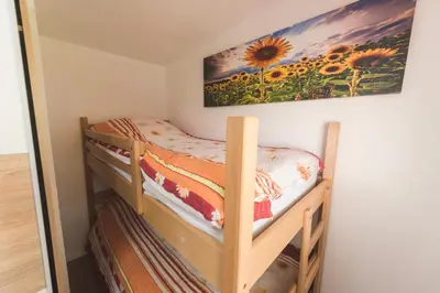 a bedroom with a bunk bed with a painting on the wall at Apartments Isabella in Ptuj