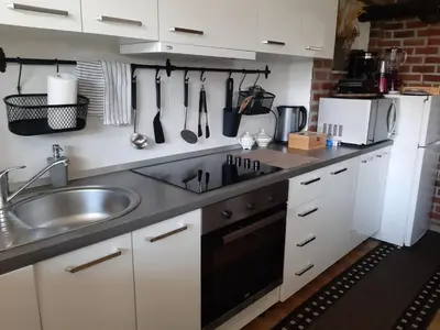 a kitchen with white cabinets and a sink at Apartments Isabella in Ptuj