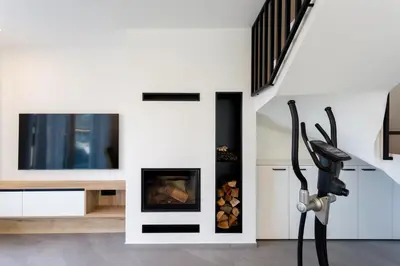 a living room with a fireplace and a tv at Hiša Urma in Celje