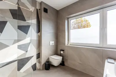 a bathroom with a toilet and a window at Hiša Urma in Celje