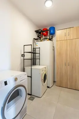 a laundry room with a washing machine and a washer at Hiša Urma in Celje