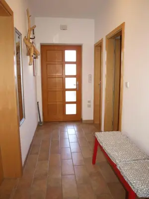 a hallway with a door and a bench in a room at Apartament VISOTA in Ptuj