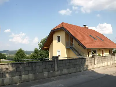 a house with a red roof on top of a wall at Apartament VISOTA in Ptuj