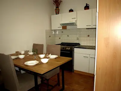 a kitchen with a wooden table with plates and bowls on it at Apartament VISOTA in Ptuj