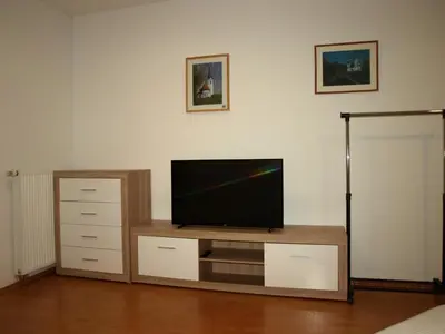 a living room with a flat screen tv on a entertainment center at Apartament VISOTA in Ptuj