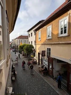 a group of people walking down a street with buildings at Staro mesto & Dragon bridge in Ljubljana