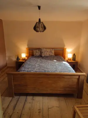a bedroom with a wooden bed with two lamps at Holidayapartement Sentjur 2 pers in Šentjur