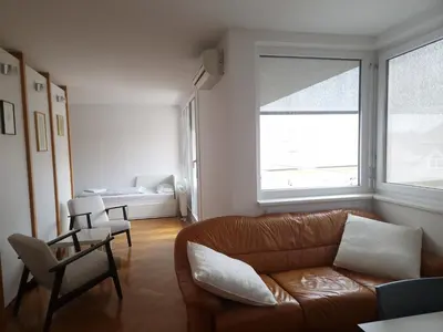 a living room with a couch and a window at Heart of Ljubljana with free parking in Ljubljana