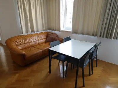 a living room with a couch and a table with chairs at Heart of Ljubljana with free parking in Ljubljana